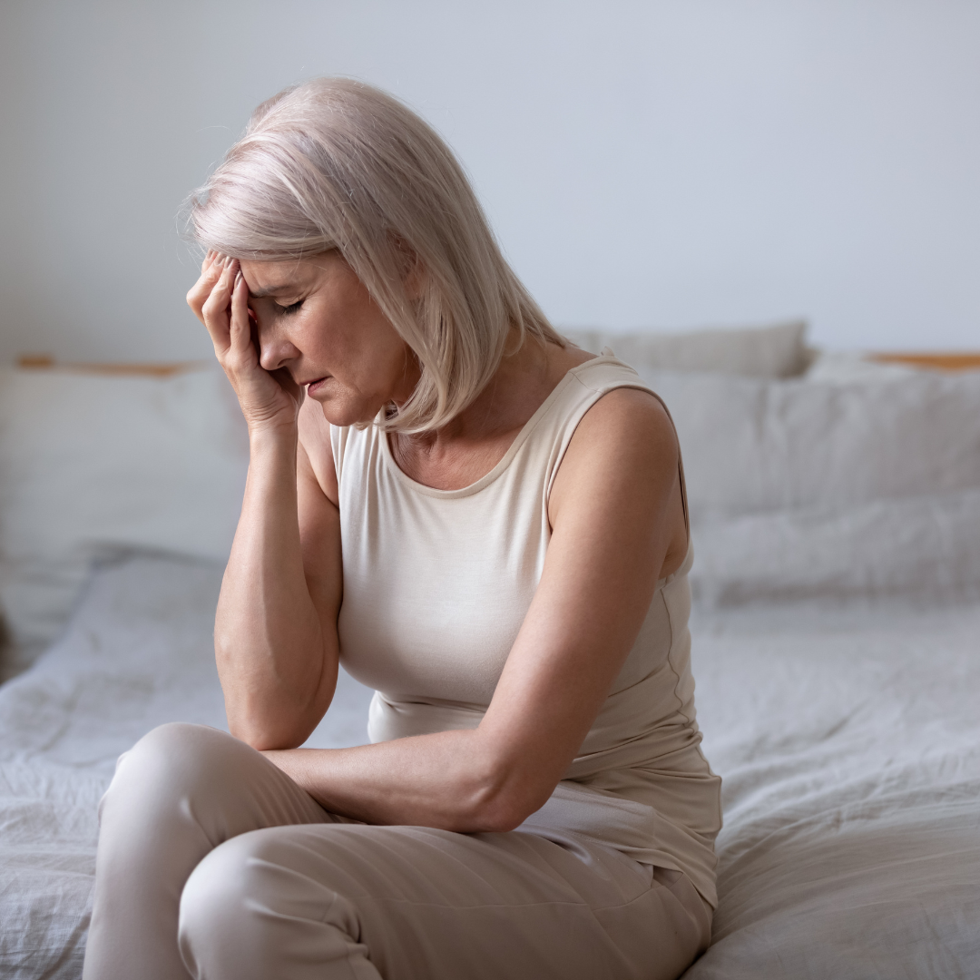 older woman sitting on bed